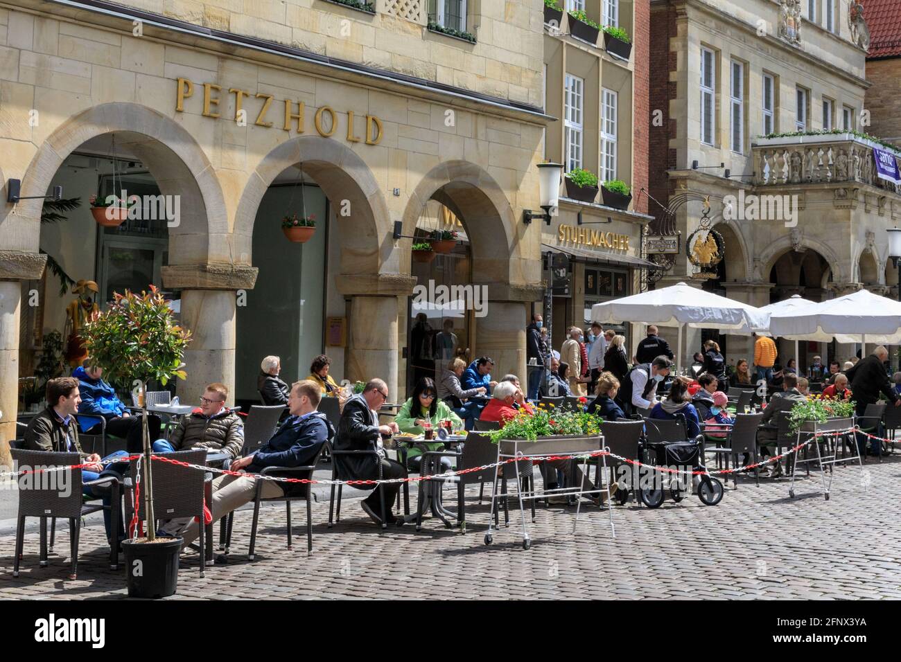 Münster, NRW, Alemania. 19th de mayo de 2021. La gente disfruta de comida y bebida al aire libre en cafés, bares y restaurantes en el centro histórico de la ciudad de Münster. Ahora se permite la apertura de la hospitalidad al aire libre, incluidos cafés y restaurantes, en Alemania, a continuación, si la incidencia por cada 100k personas se mantiene por debajo de 100 durante al menos 5 días seguidos, en ciudades o consejos individuales. La ciudad de Münster, de tamaño medio y relativamente acomodada, ha experimentado tasas de incidencia bastante bajas durante toda la pandemia y, actualmente en 16,5/100k, está muy por debajo de la tasa media de incidencia alemana de 72. 8. Crédito: Imageplotter/Alamy Live News Foto de stock