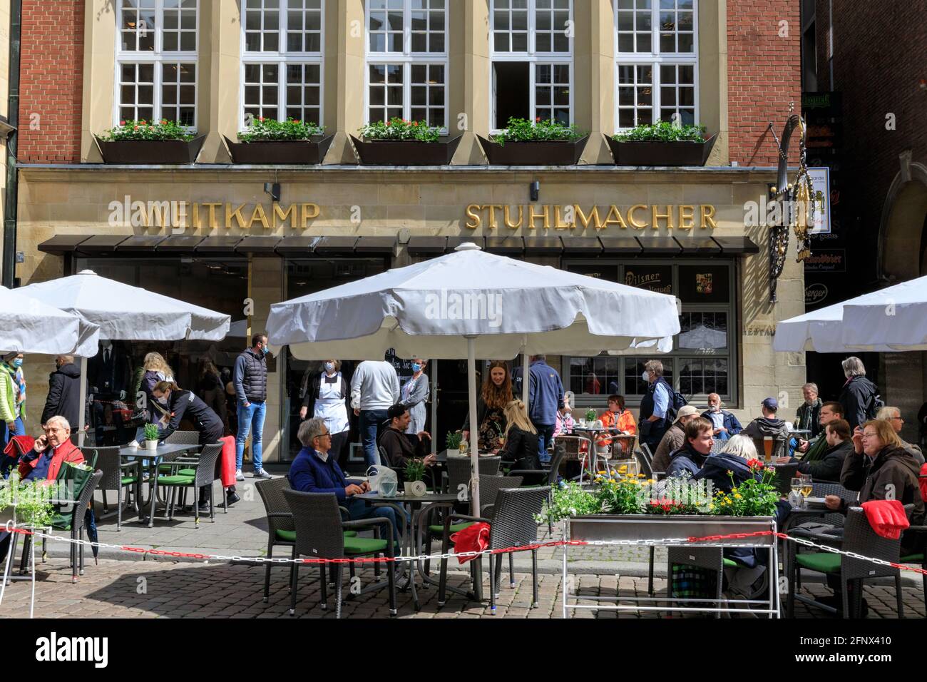Münster, NRW, Alemania. 19th de mayo de 2021. La gente disfruta de comida y bebida al aire libre en cafés, bares y restaurantes en el centro histórico de la ciudad de Münster. Ahora se permite la apertura de la hospitalidad al aire libre, incluidos cafés y restaurantes, en Alemania, a continuación, si la incidencia por cada 100k personas se mantiene por debajo de 100 durante al menos 5 días seguidos, en ciudades o consejos individuales. La ciudad de Münster, de tamaño medio y relativamente acomodada, ha experimentado tasas de incidencia bastante bajas durante toda la pandemia y, actualmente en 16,5/100k, está muy por debajo de la tasa media de incidencia alemana de 72. 8, Crédito: Imageplotter/Alamy Live News Foto de stock