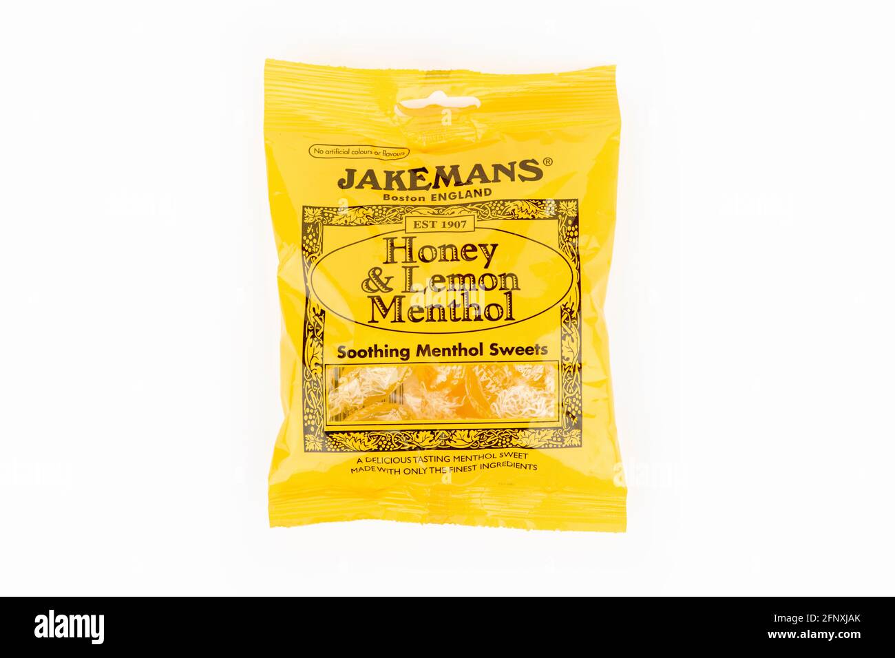 Un paquete de miel Jakemans y dulces de mentol limón tiraron sobre un fondo blanco. Foto de stock