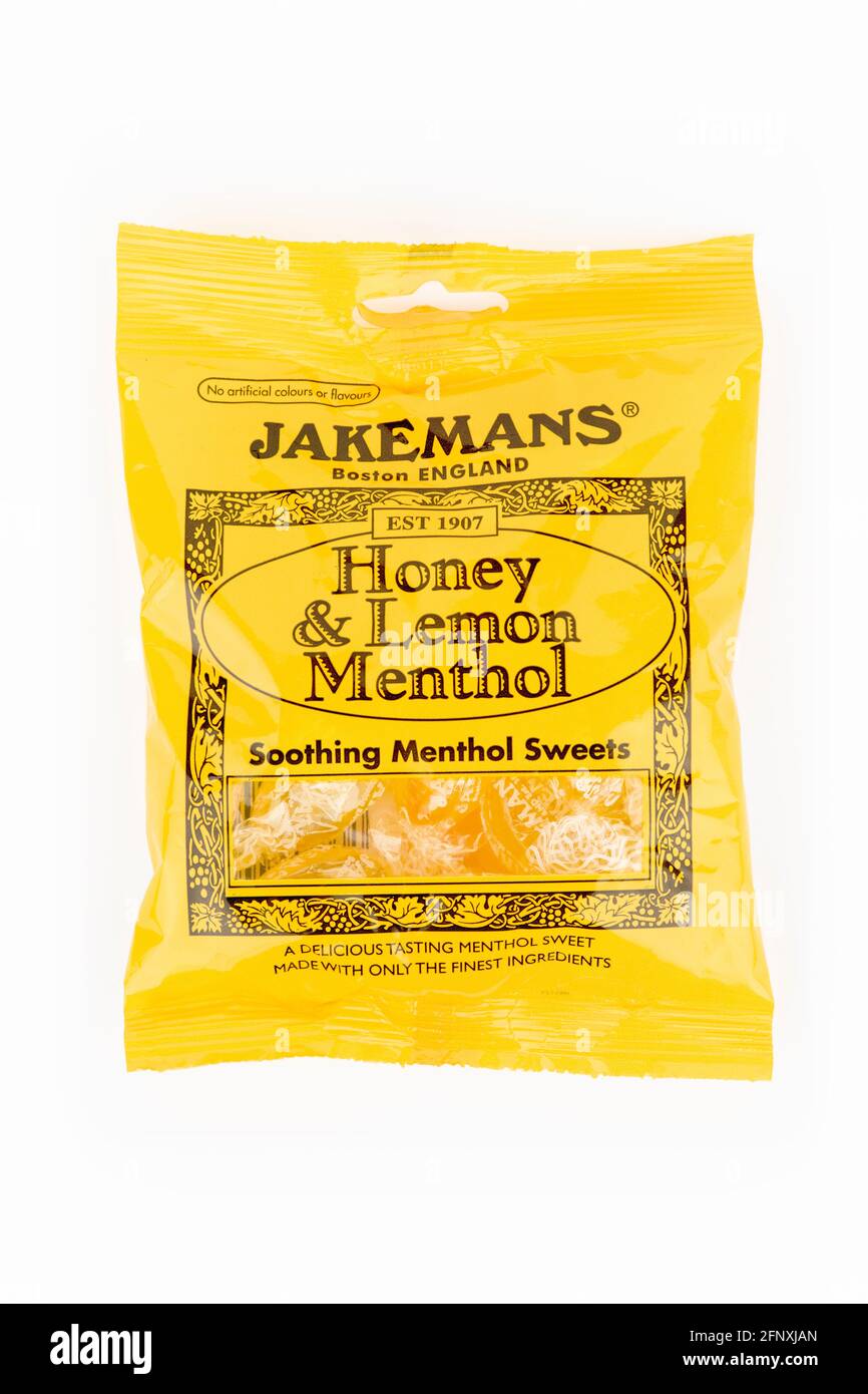 Un paquete de miel Jakemans y dulces de mentol limón tiraron sobre un fondo blanco. Foto de stock