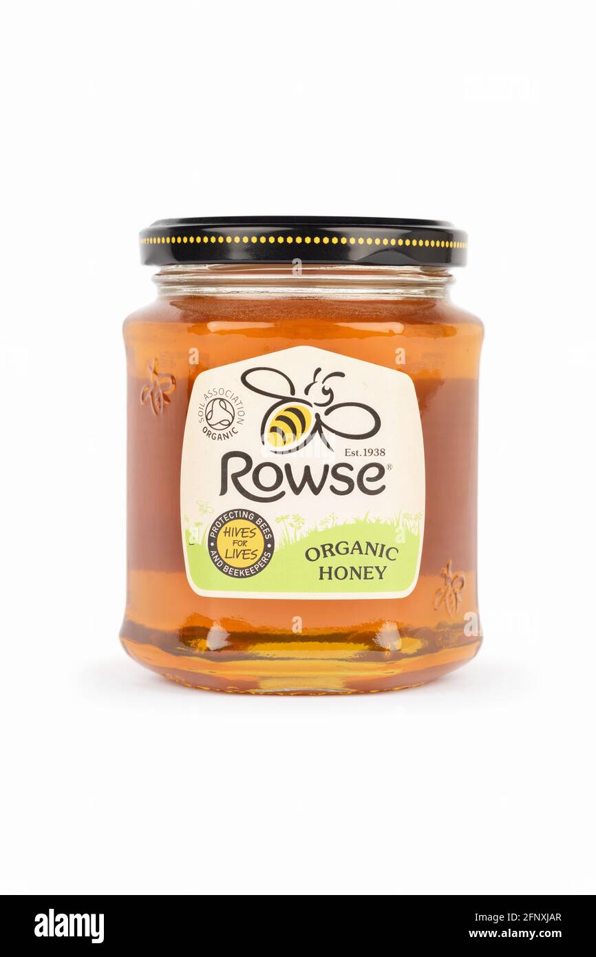 Una jarra de miel orgánica Rowse rodó sobre un fondo blanco. Foto de stock