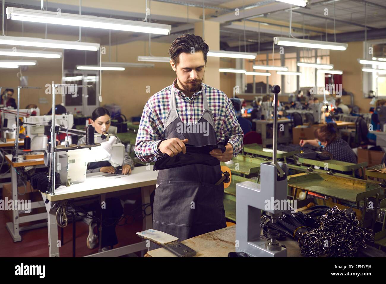 Un artesano experimentado que trabaja en una fábrica de artículos de cuero  se está preparando para fabricar nuevos cinturones Fotografía de stock -  Alamy