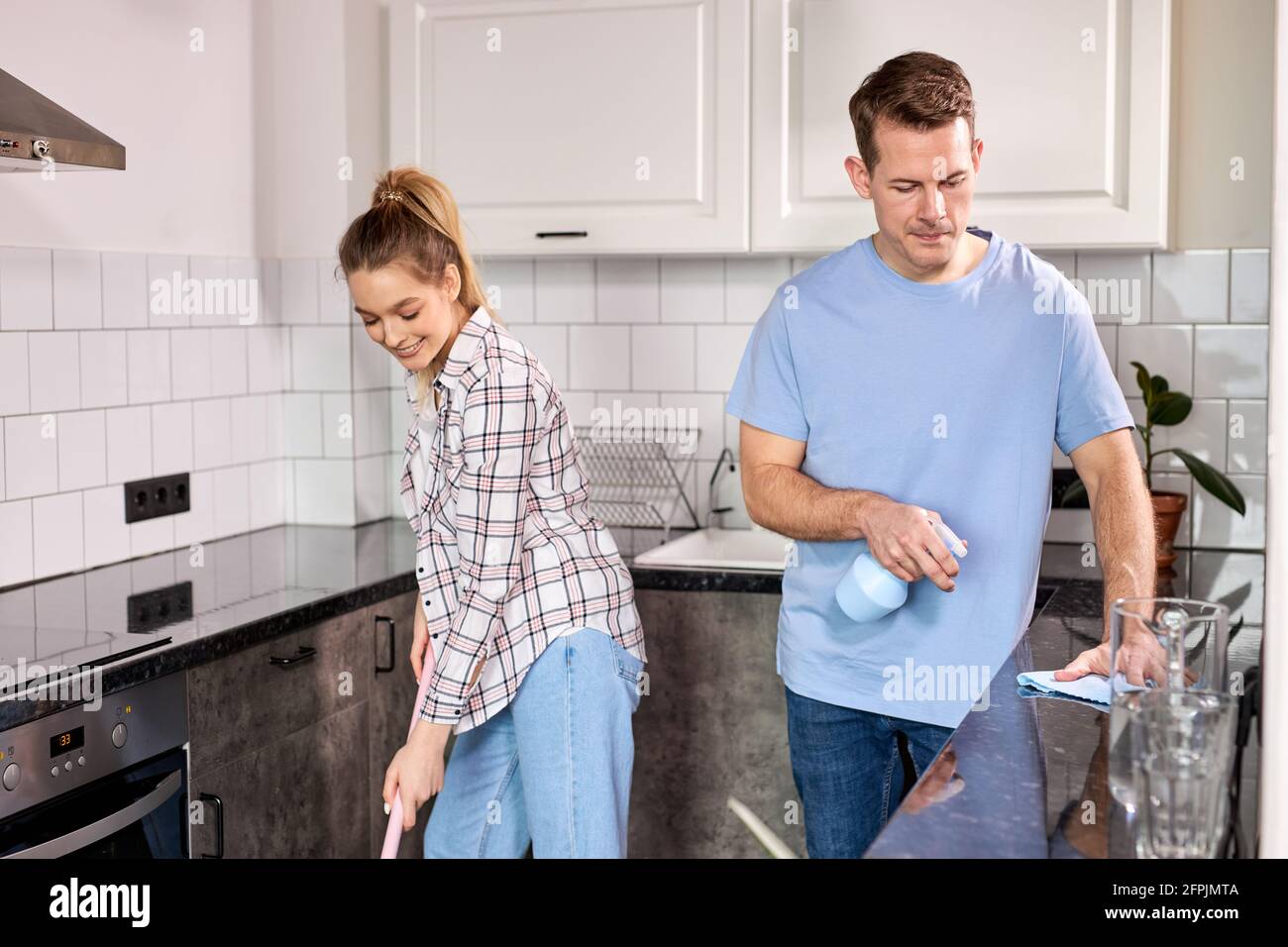 Limpieza De Casa Casa De Limpieza Para Parejas Jóvenes En La Cocina Mujer Limpiando Piso Con 