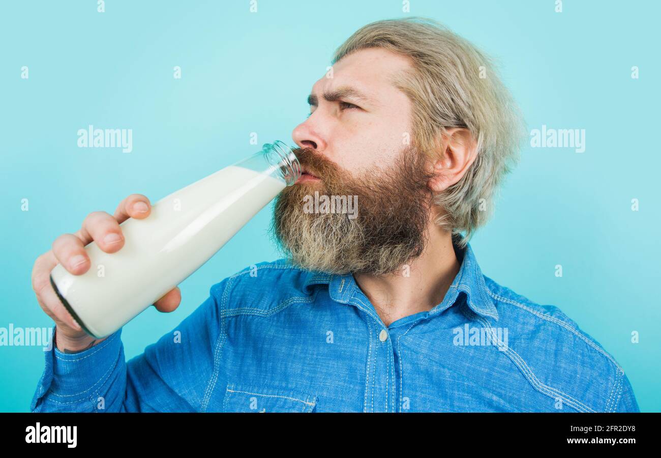 El hombre barbudo bebe leche fresca. Productos de lactosa. Hombre con botella de leche. Leche sin lactosa. Foto de stock