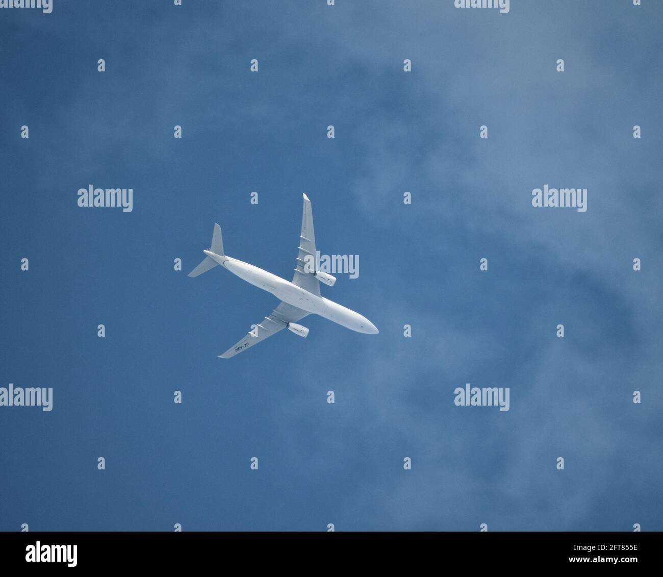 Un avión de pasajeros comercial vuela por encima de las nubes Foto de stock