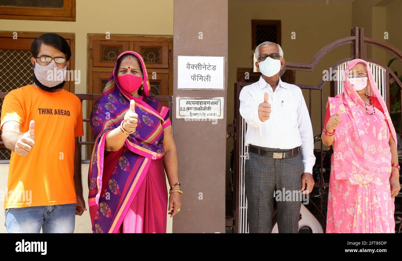 Beawar, Rajasthan, India, 21 de mayo de 2021: Miembros de una familia aplicaron el cartel 'Familia Vacunada' fuera de su casa después de recibir dosis de la vacuna COVID-19, primera iniciativa de su tipo para alentar a las personas durante la segunda ola de pandemia de coronavirus en Beawar. El Vicepresidente Nacional del BJP y el ex Ministro Principal Vasundhara Raje apreciaron a esta familia de Satyanarayan Sharma en los medios sociales. El cartel presentó un objetivo de eliminar las ideas erróneas sobre la vacunación contra Covid-19 y de animar a las personas con respecto a la vacuna contra la enfermedad de coronavirus. Crédito: Sumit Saraswat/Alamy Live News Foto de stock