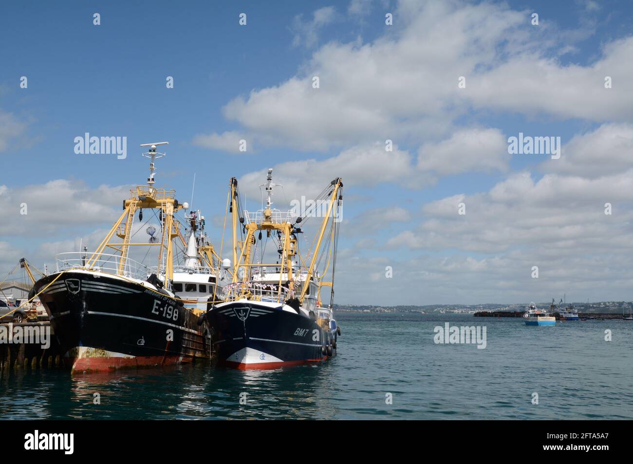 Barcos de pesca amarrados en el puerto de Brixham en Devon, Inglaterra. En el fondo un pequeño taxi barco que lleva a los pasajeros a Torquay en la distancia Foto de stock