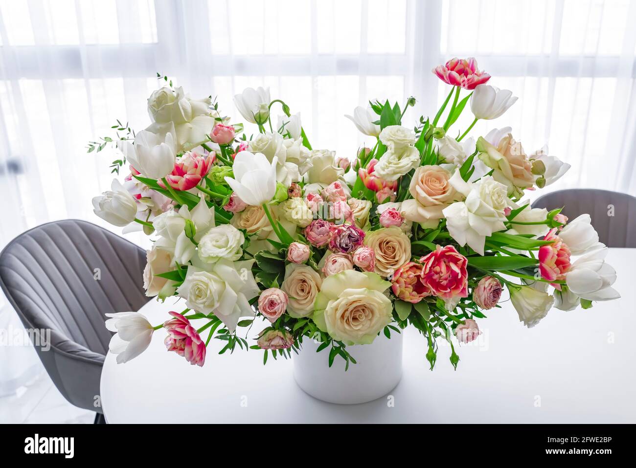 Bouquet de tulipanes y rosas de color rosa y blanco decora la mesa de  conferencias, fondo claro, lugar para texto. Primavera сard, bandera  Fotografía de stock - Alamy