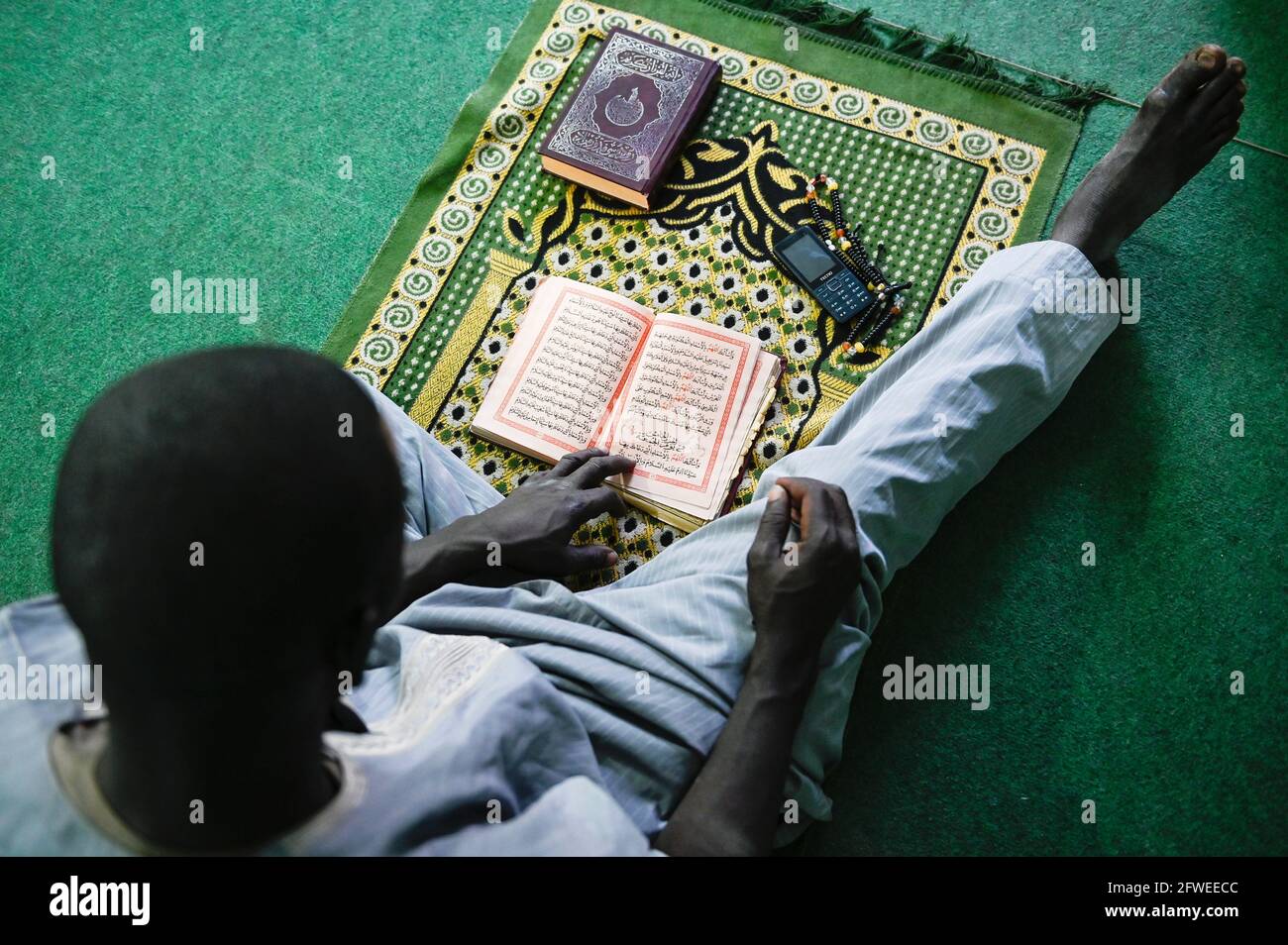 MALI, Kayes, mezquita, musulmán sentado en la alfombra de oración y lee un libro islámico / Moschee, auf musulmán Gebetsteppich im Gebet Foto de stock