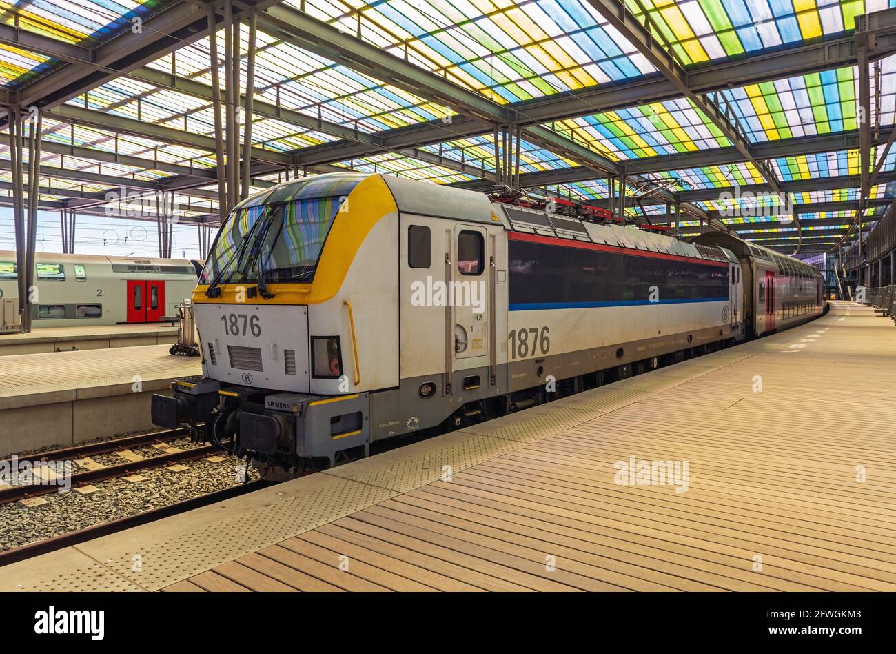 Locomotora de tren con vagones en la moderna estación de tren de Ostende (Oostende) ciudad con plataforma, Bélgica. Foto de stock