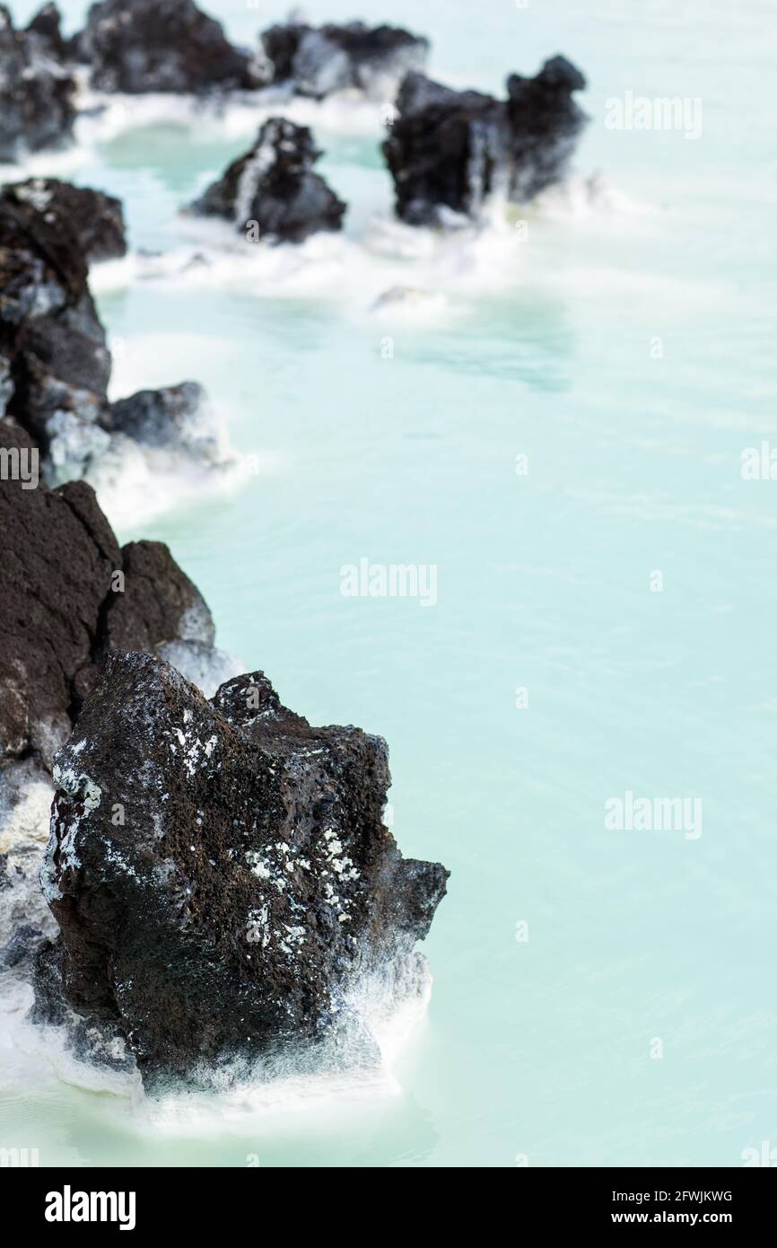 Cerca de las rocas de lava y el barro de las aguas termales Sedimento en el Blue Lagoon Resort and Spa al amanecer En Islandia Foto de stock