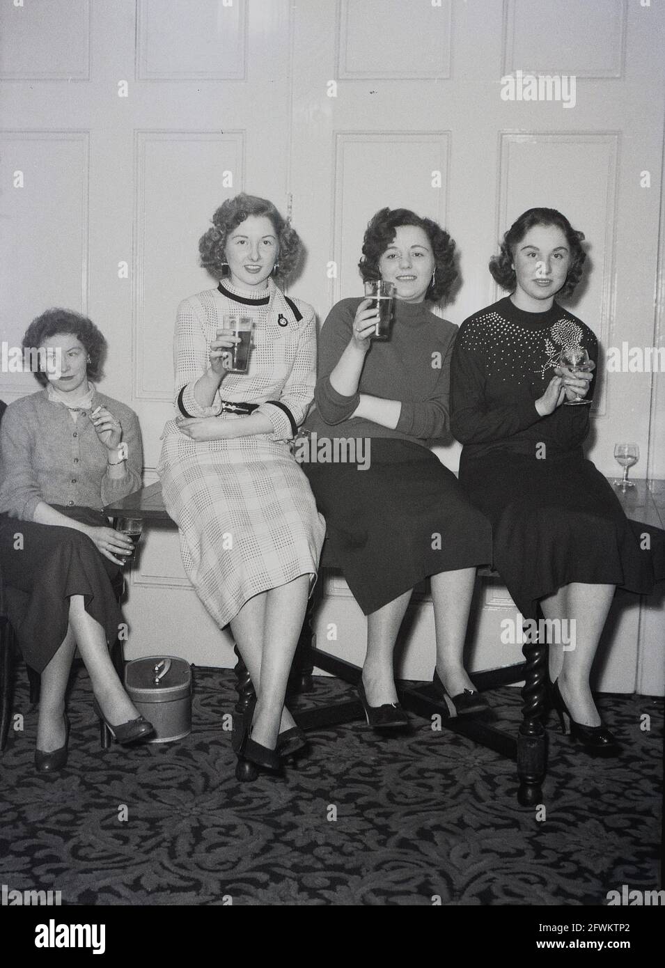1957, histórico, en una fiesta o hacer de la compañía, dentro de una sala  de actos en el Hotel Victoria, Leeds, tres mujeres jóvenes sentadas en una  mesa, dos con mostrar sus