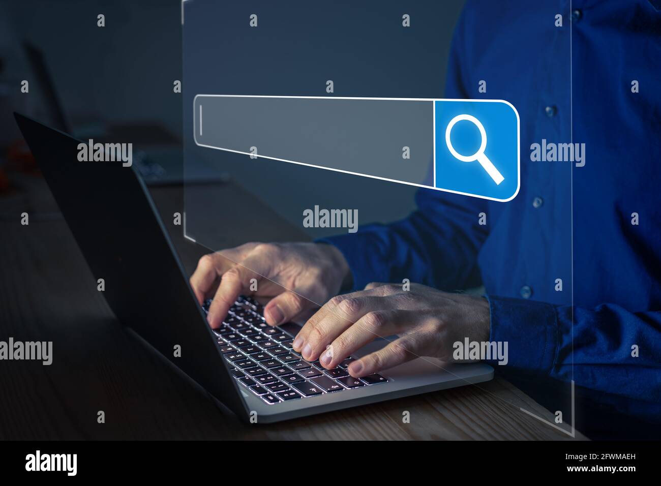 Búsqueda en Internet con una persona utilizando un navegador de ordenador portátil para abrir el motor de búsqueda con barra de texto y un icono de lupa. Acceso en Foto de stock