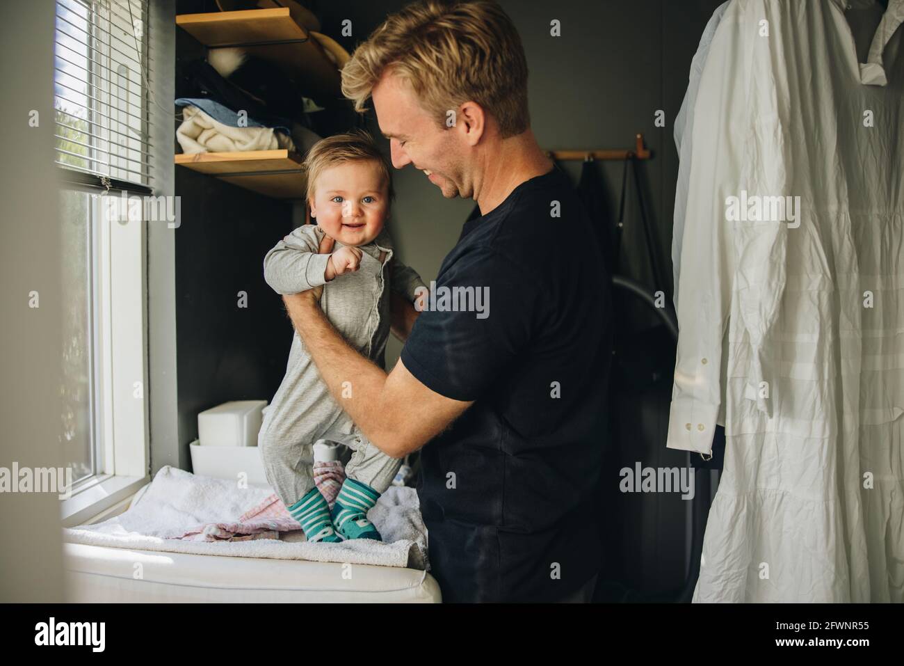 Padre que prepara a su hijo en casa. Hombre en licencia de maternidad ...