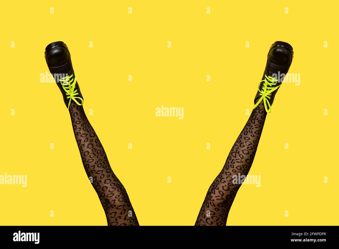 Nuevas botas para mujer grises con cordones amarillos brillantes en largas  y delgadas piernas para mujer en medias con estampado de tigre gris  aisladas sobre fondo amarillo Fotografía de stock - Alamy