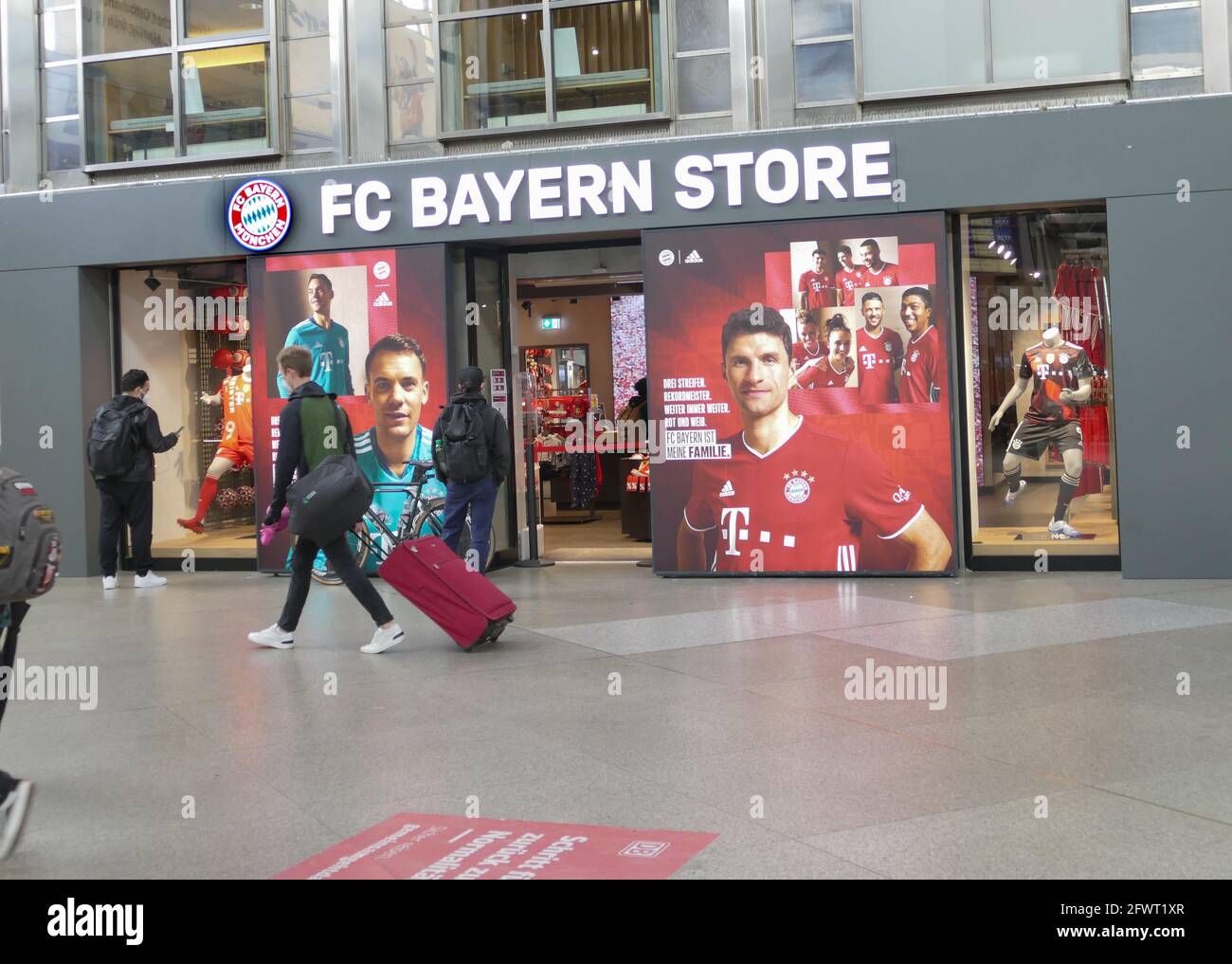 Tienda profesional FC Bayern, estación principal de Múnich. Viajero con una  maleta de tranvía que pasa por la gran ventana de la tienda Fotografía de  stock - Alamy