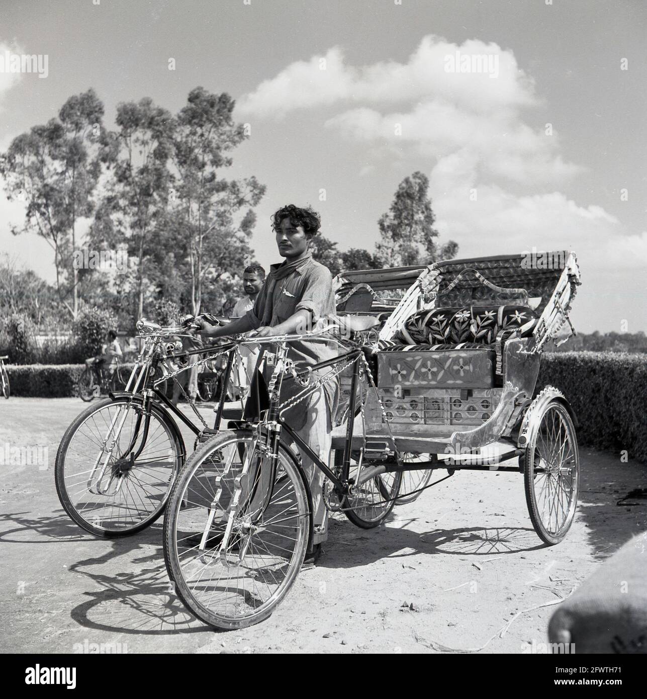 1950s, Indian bike taxi, con los conductores esperando a los clientes,  India, estos rickstraw de ciclo eran transporte local a pequeña escala, una  especie de triciclo de berlina, y llevaría a los