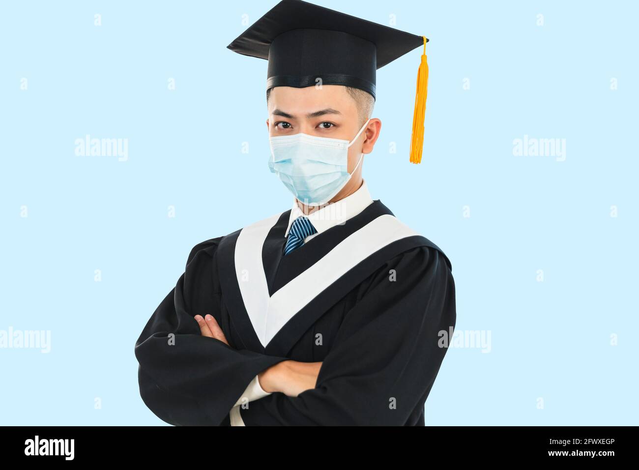 graduación masculina joven con máscara facial durante la pandemia del coronavirus Foto de stock