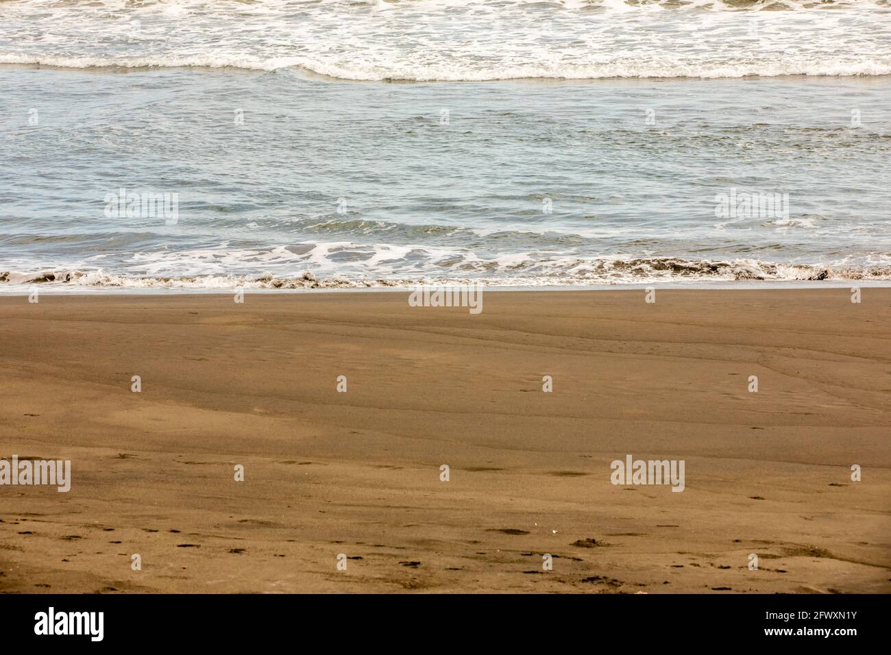 Vista de la playa negra volcánica y de las olas del océano Pacífico en Playa Hermosa en North Puntarenas, Costa Rica Foto de stock