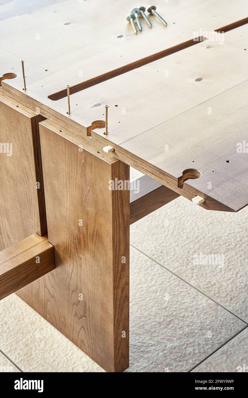 Montaje de una gran mesa de comedor de madera con conectores de encimera y.  tornillos al aire libre en el día soleado vista extrema cerca Fotografía de  stock - Alamy