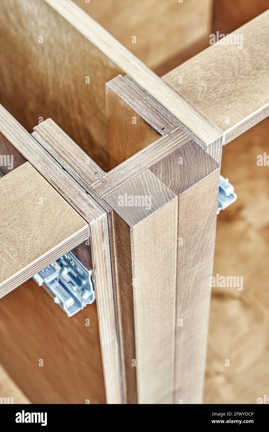 Detalle de muebles de cocina de madera contrachapada y ceniza sólida pared de ladrillo instalado en madera vista muy cerca Foto de stock
