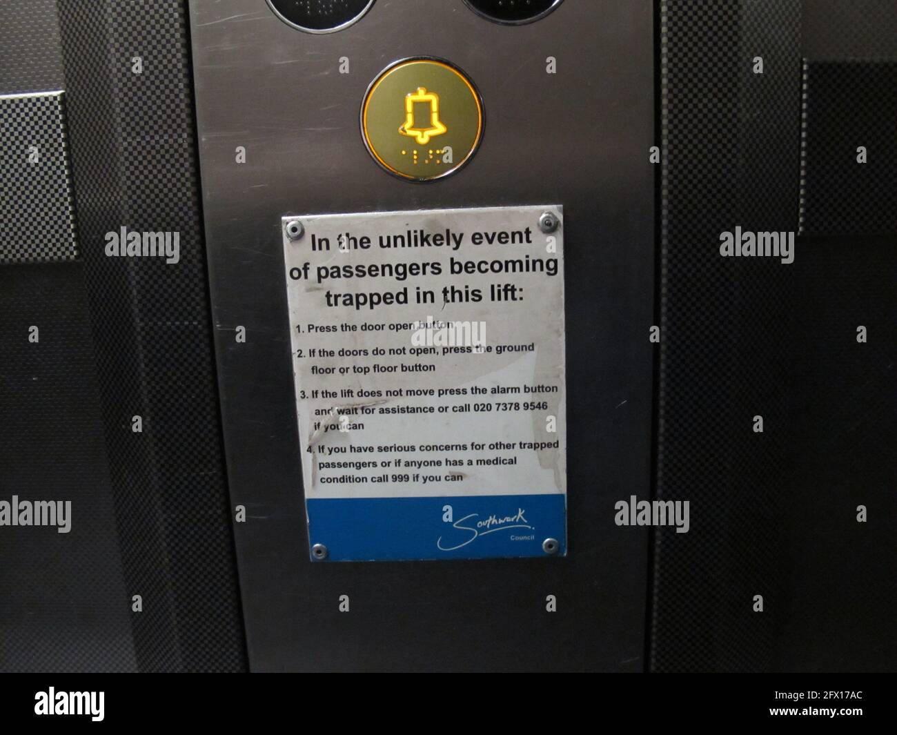 Firme dentro de un ascensor del consejo de Southwark con instrucciones en caso se bloquea y la gente queda atrapada en el ascensor Foto de stock