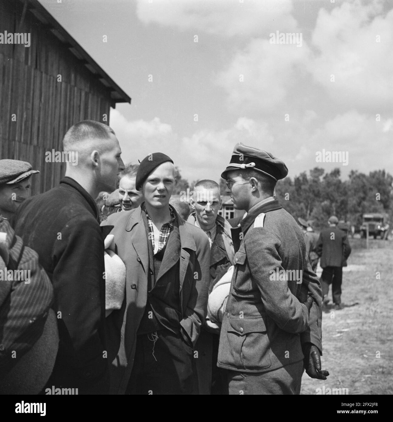 Hombre con uniforme hablando con hombres vestidos de civil, junio de 1945,  campamentos de internamiento, prisioneros de guerra, militares, Países  Bajos, agencia de prensa del siglo 20th foto, noticias para recordar,  documental,