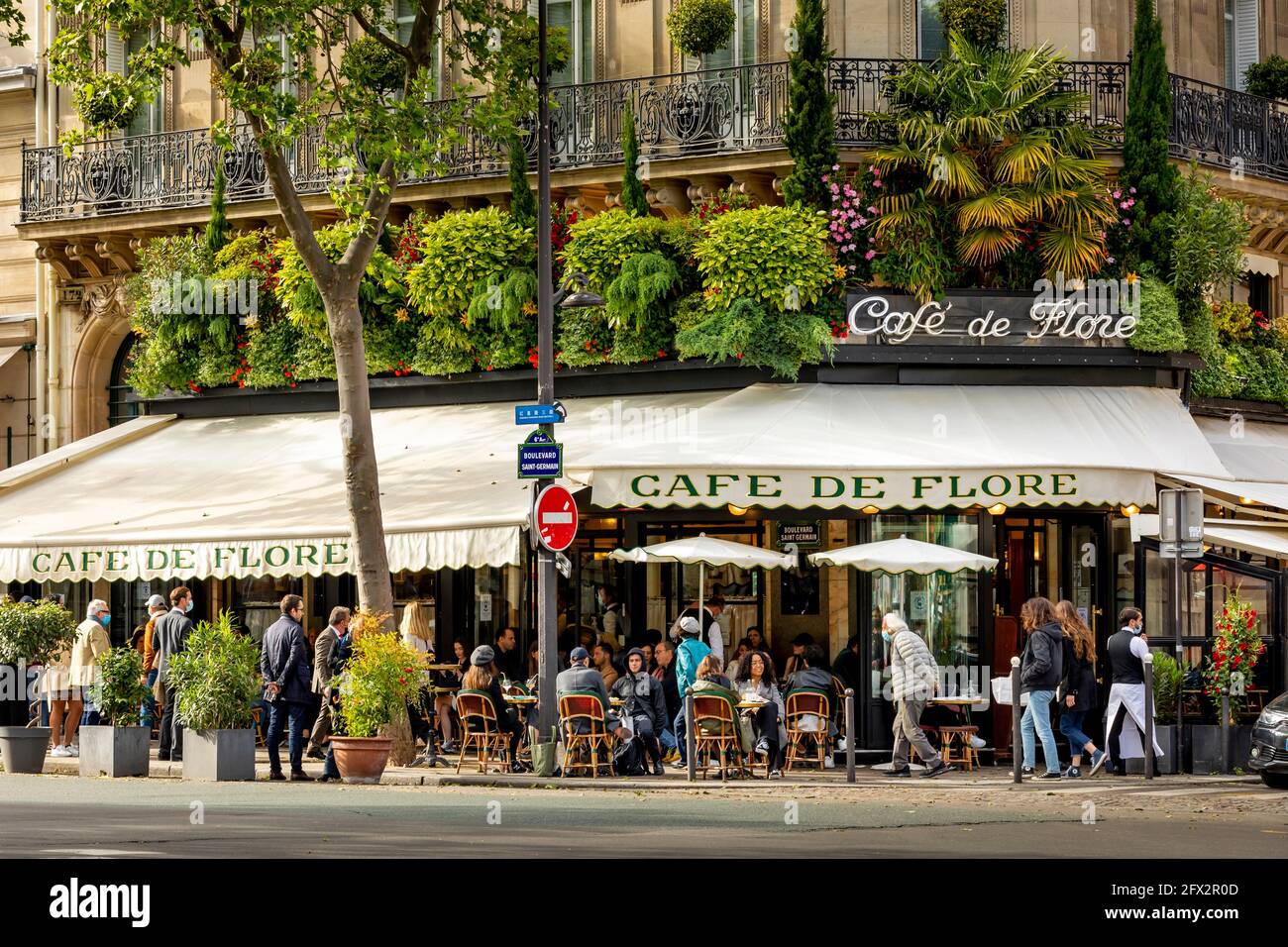 París, Francia - 19 de mayo de 2021: Día después del cierre debido al covid-19 en un famoso café parisino. 2 camareros llevan máscaras quirúrgicas Foto de stock