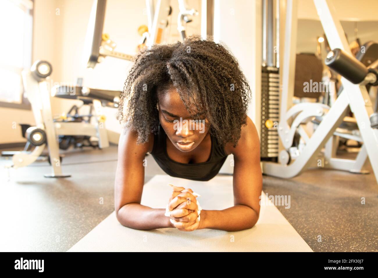 https://c8.alamy.com/compes/2fx30j7/chica-hermosa-en-el-gimnasio-chica-deportiva-en-el-entrenamiento-de-ropa-deportiva-una-persona-de-cerca-mujer-negra-afroamericana-pelo-natural-de-fondo-gimnasio-2fx30j7.jpg