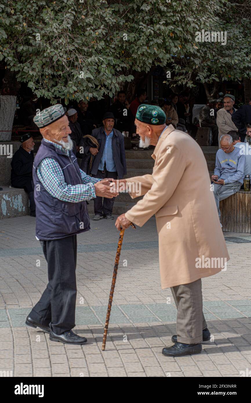 Dos ancianos uigures que se encuentran fuera de la Mezquita de Id Kah .Kashgar, Xingiang, China 2019 Foto de stock