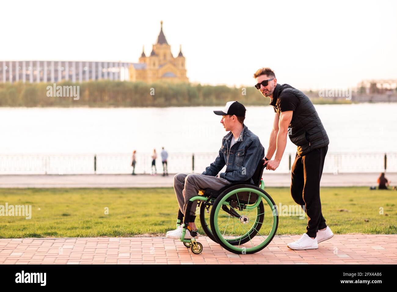 Ayuda para personas con discapacidades físicas. Hombre conducir silla de  ruedas y ayudar a su amigo. Servicios sociales para la población Fotografía  de stock - Alamy