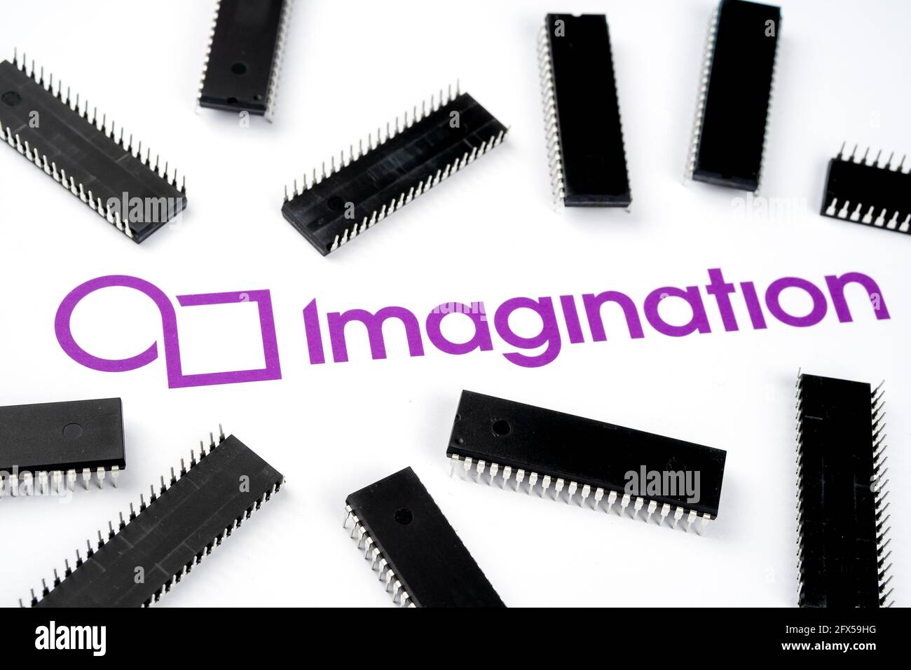 Logotipo de la compañía Imagination en el documento de papel y microchips grandes colocados alrededor. Ilustrativo para el fabricante de chips electrónicos. Enfoque selectivo. St Foto de stock