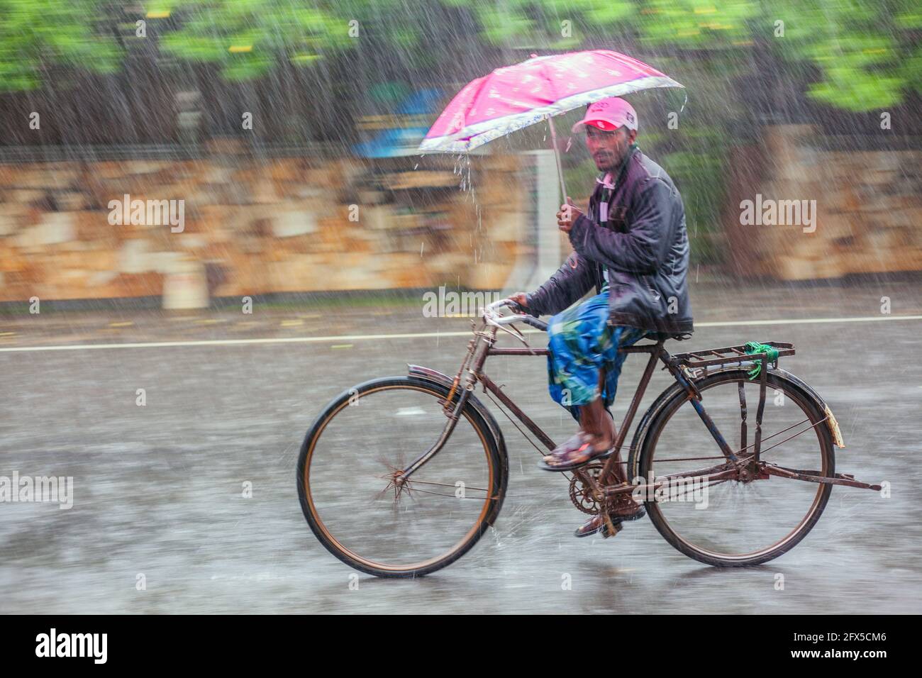 Sri Lanka paseos en bicicleta con sombrilla bajo lluvia torrencial (tomada  con la técnica de cámara panorámica), Bahía de Arugam, Provincia Oriental, Sri  Lanka Fotografía de stock - Alamy