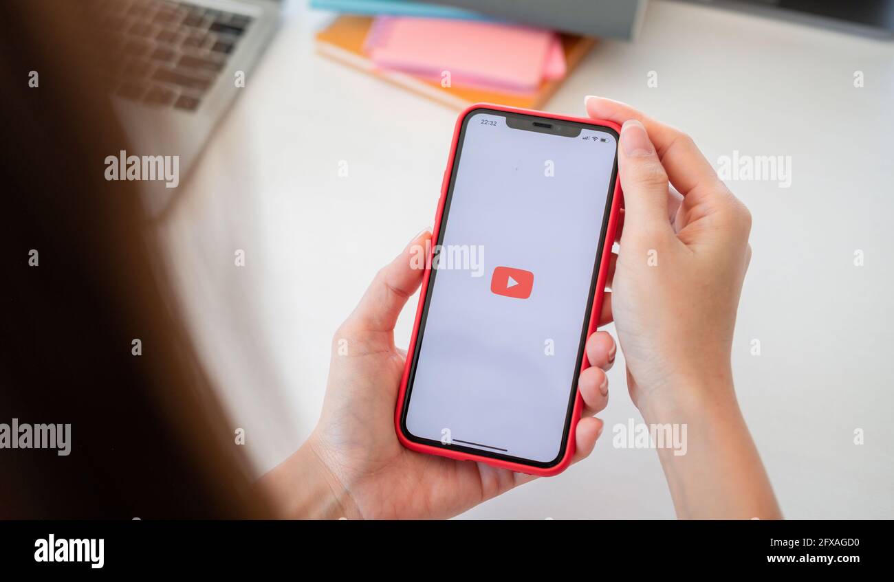 CHIANG MAI, THD - 20 DE MAYO de 2021: Mujer de mano que sostiene Apple iPhone 11 con App YouTube ofrece streaming de medios y vídeo en la pantalla Foto de stock