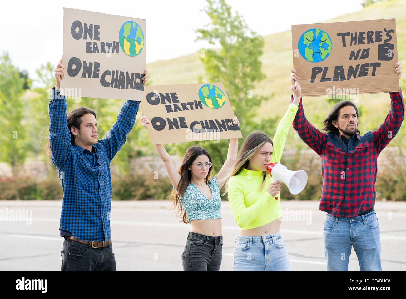 Mujer activista enojada con megáfono anunciando mientras protestaba por el cambio climático Foto de stock