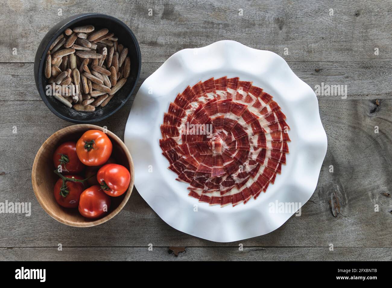 Tomates y rodajas de carne roja en la mesa Foto de stock