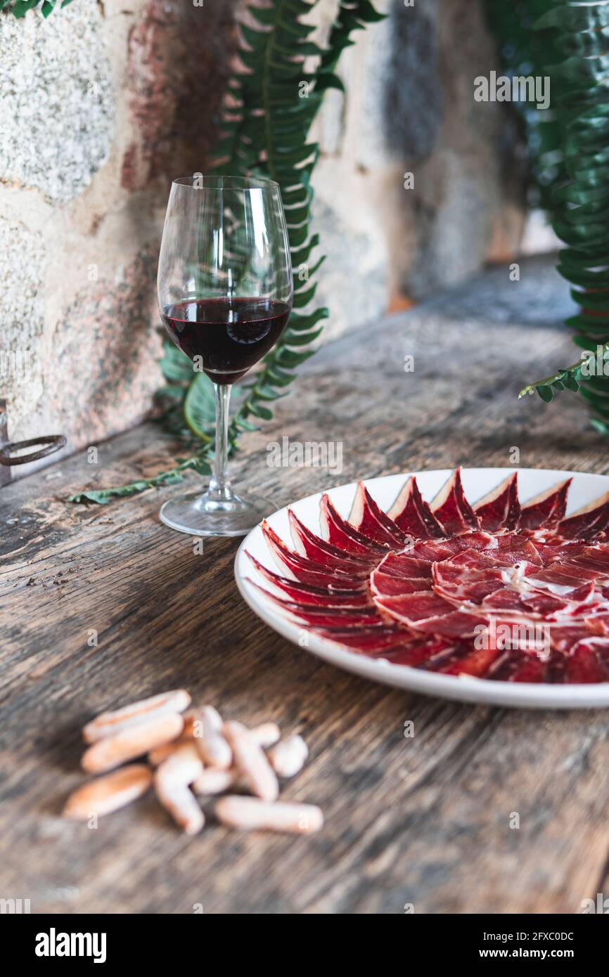 Rodaja de carne roja en plato sobre mesa por bebida Foto de stock