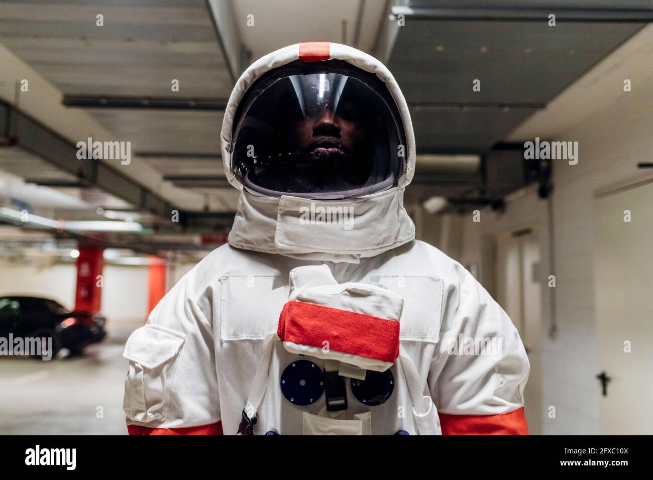 Astronauta adulto medio con casco espacial de pie en el