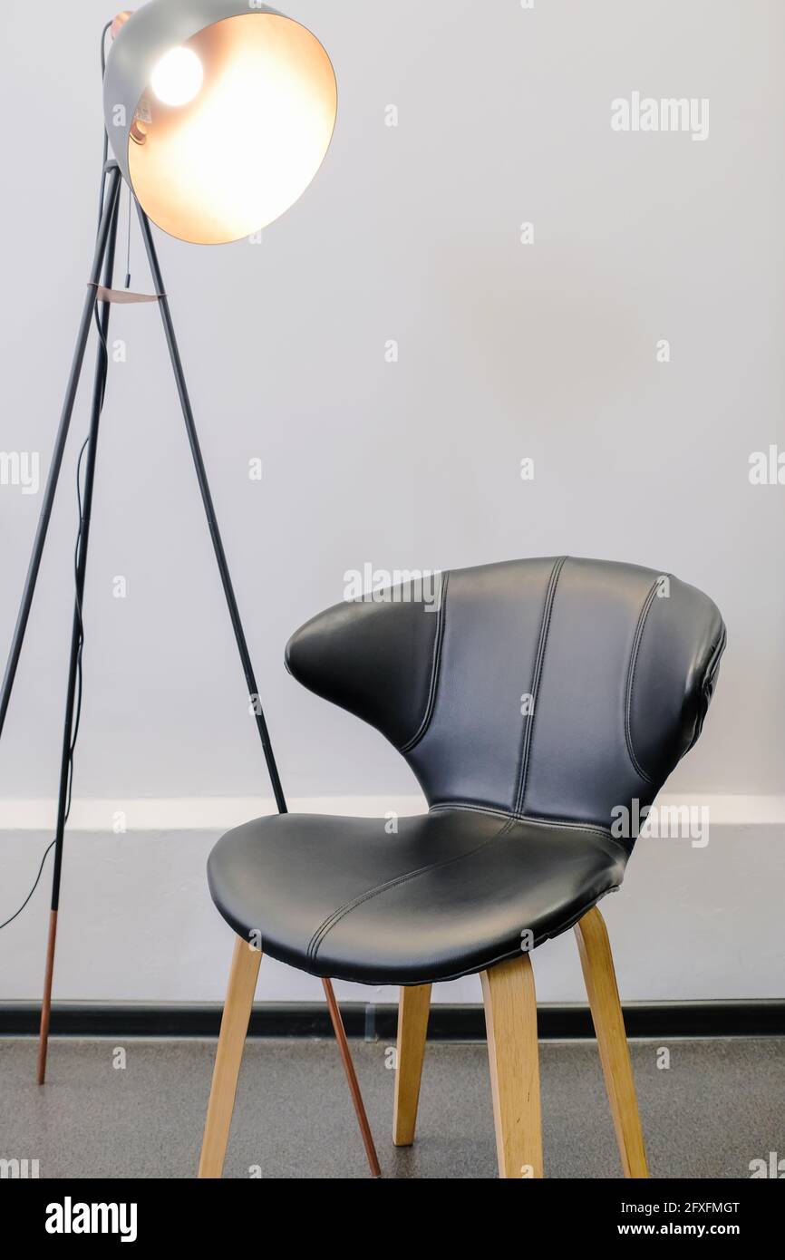 Lámpara de pie con silla negra. Interior para una foto, video blogging. Concepto de silla del director. Interiores minimalistas. Foto de stock