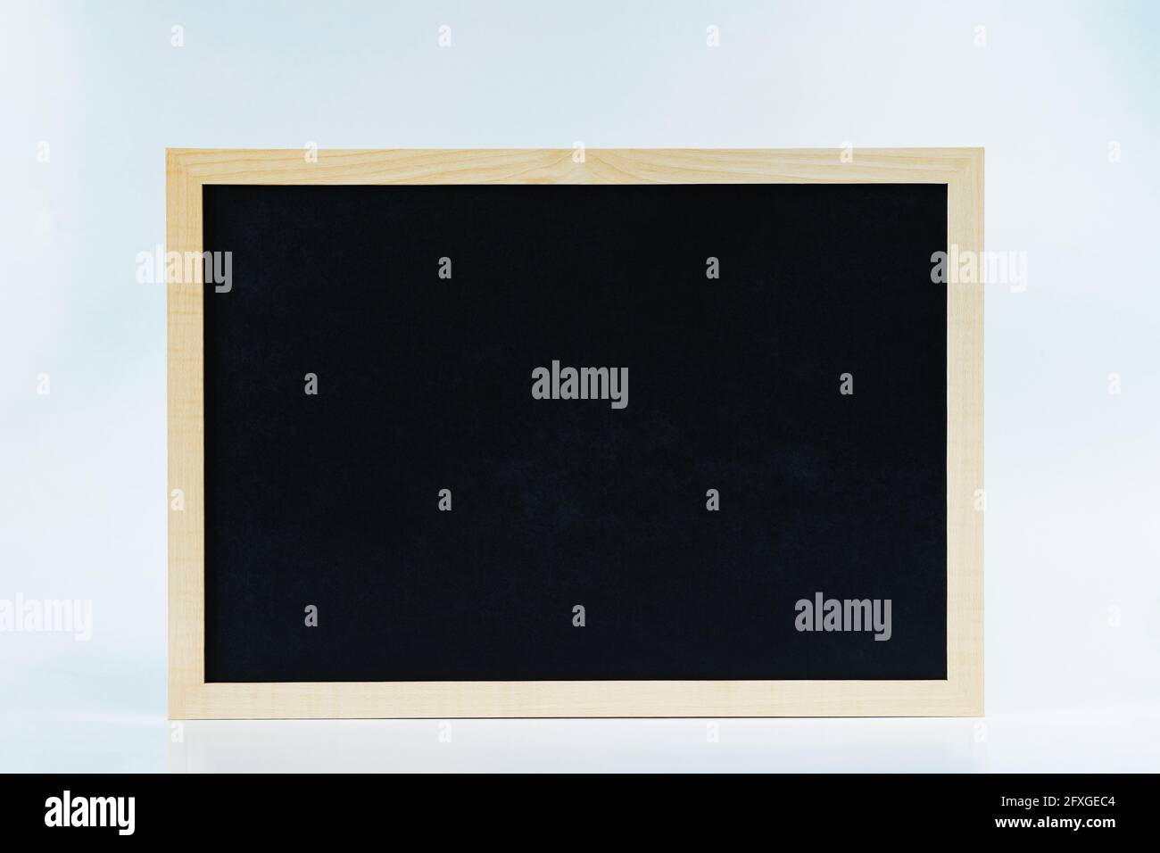 Signo de pizarra en blanco en marco de madera sobre fondo blanco para almacenar anuncios Foto de stock