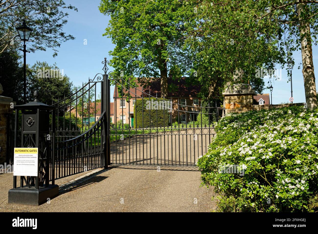 Una urbanización cerrada en el sur de Inglaterra. Puertas eléctricas de  hierro forjado a una exclusiva zona residencial Fotografía de stock - Alamy
