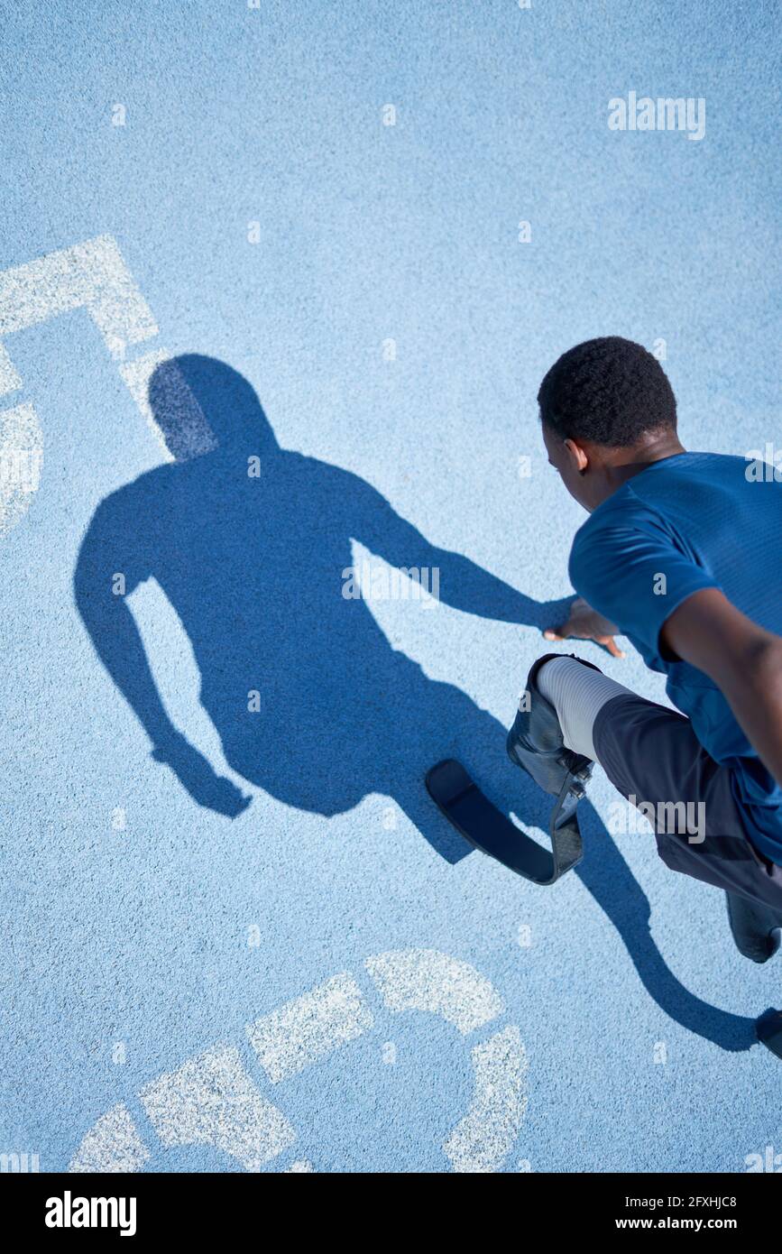 Joven hombre amputado sprinter listo en azul soleado pista de deportes  Fotografía de stock - Alamy
