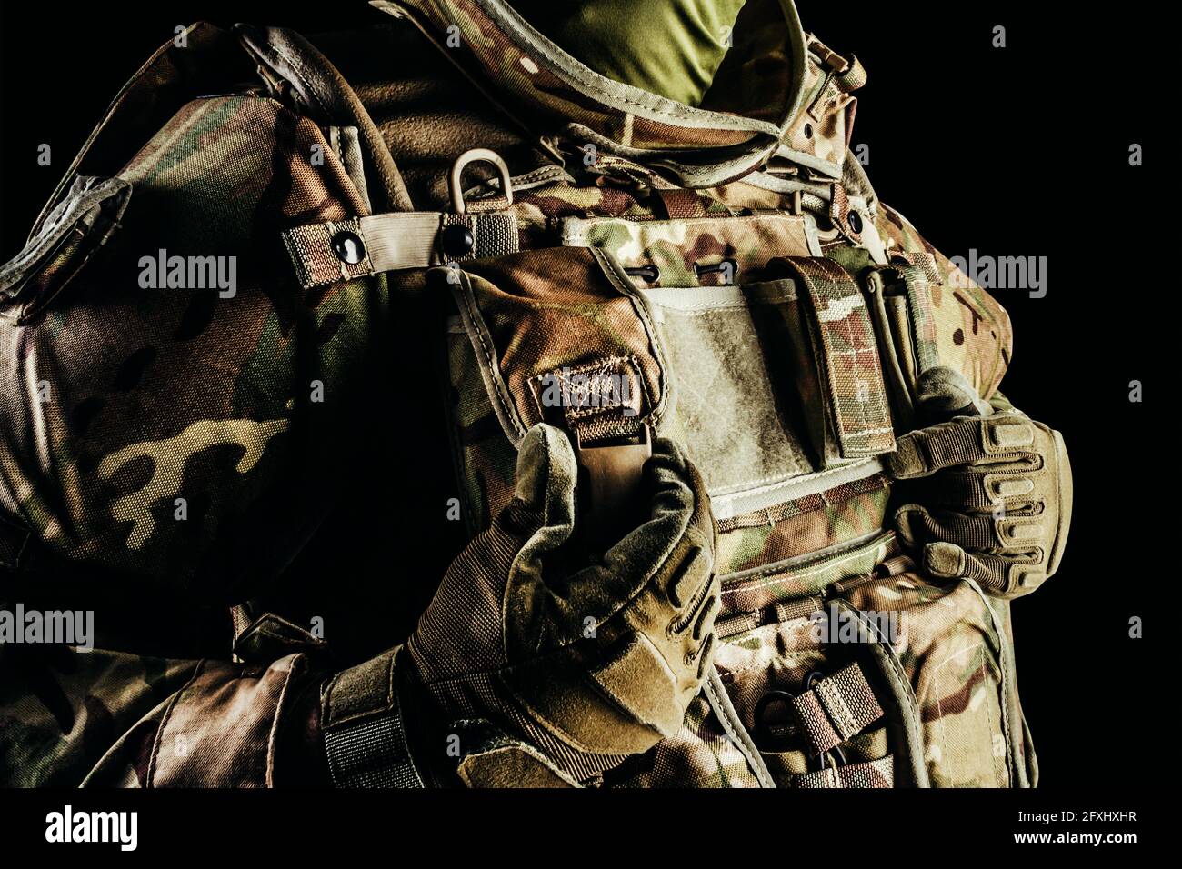 Foto de soldado en nivel 3 munición de chaleco blindada, guantes tácticos con bolsa sobre fondo negro. Foto de stock