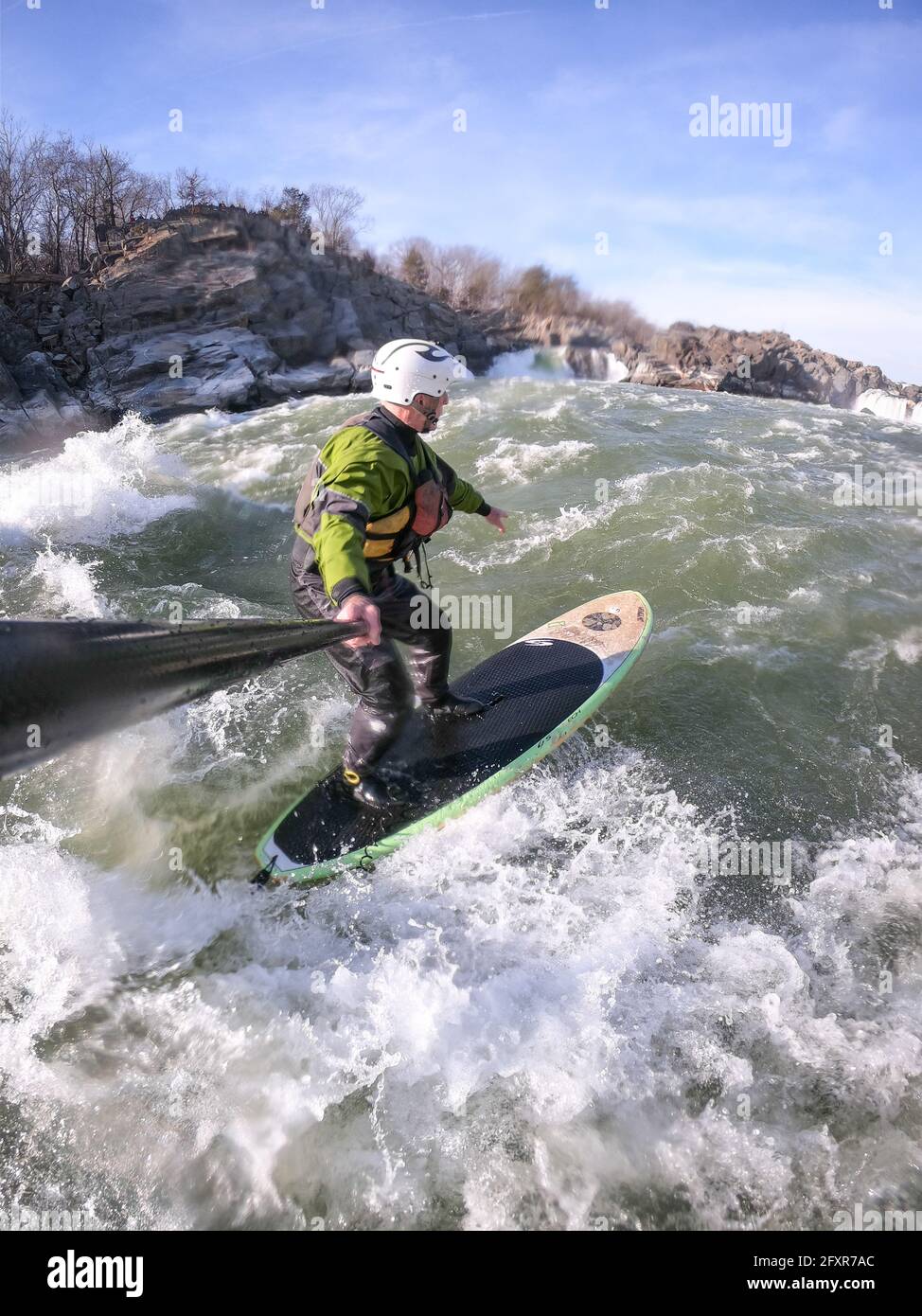 Fotógrafo Skip Brown stand up paddle surfs en invierno desafiando aguas blancas por debajo de las Great Falls del río Potomac, EE.UU. Foto de stock