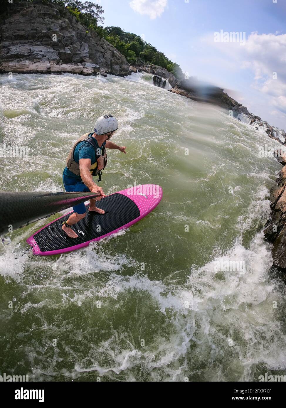 Fotógrafo Skip Brown stand up paddle surfes desafiantes aguas blancas debajo de las Great Falls del río Potomac, frontera de Maryland y Virginia, Estados Unidos Foto de stock