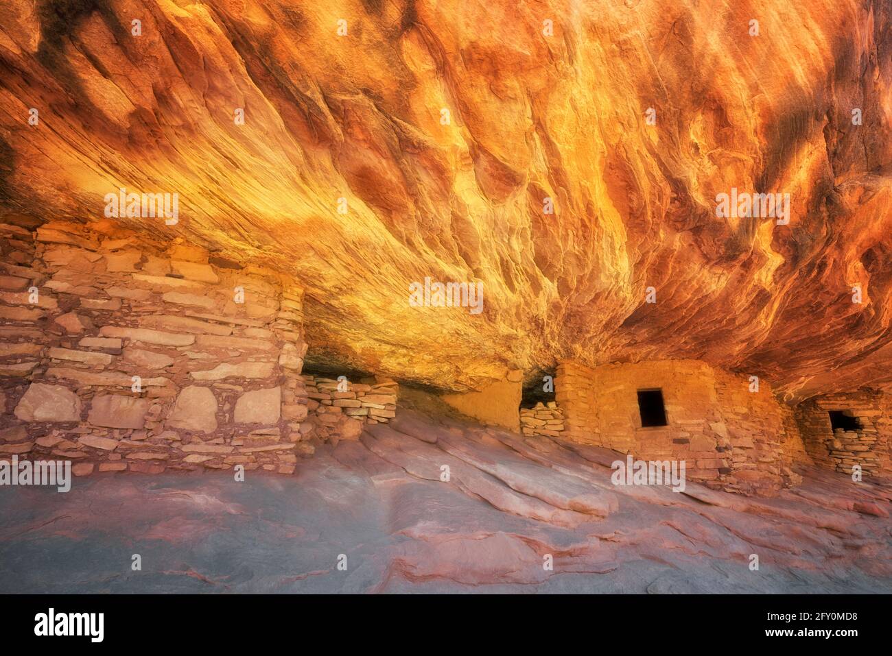 La luz del sol reflectante ilumina la roca de arenisca sobre esta antigua Anasazi Granario y acertadamente nombrado Casa en Ruin Fuego Cedar Mesa Pl, de SE Utah Foto de stock