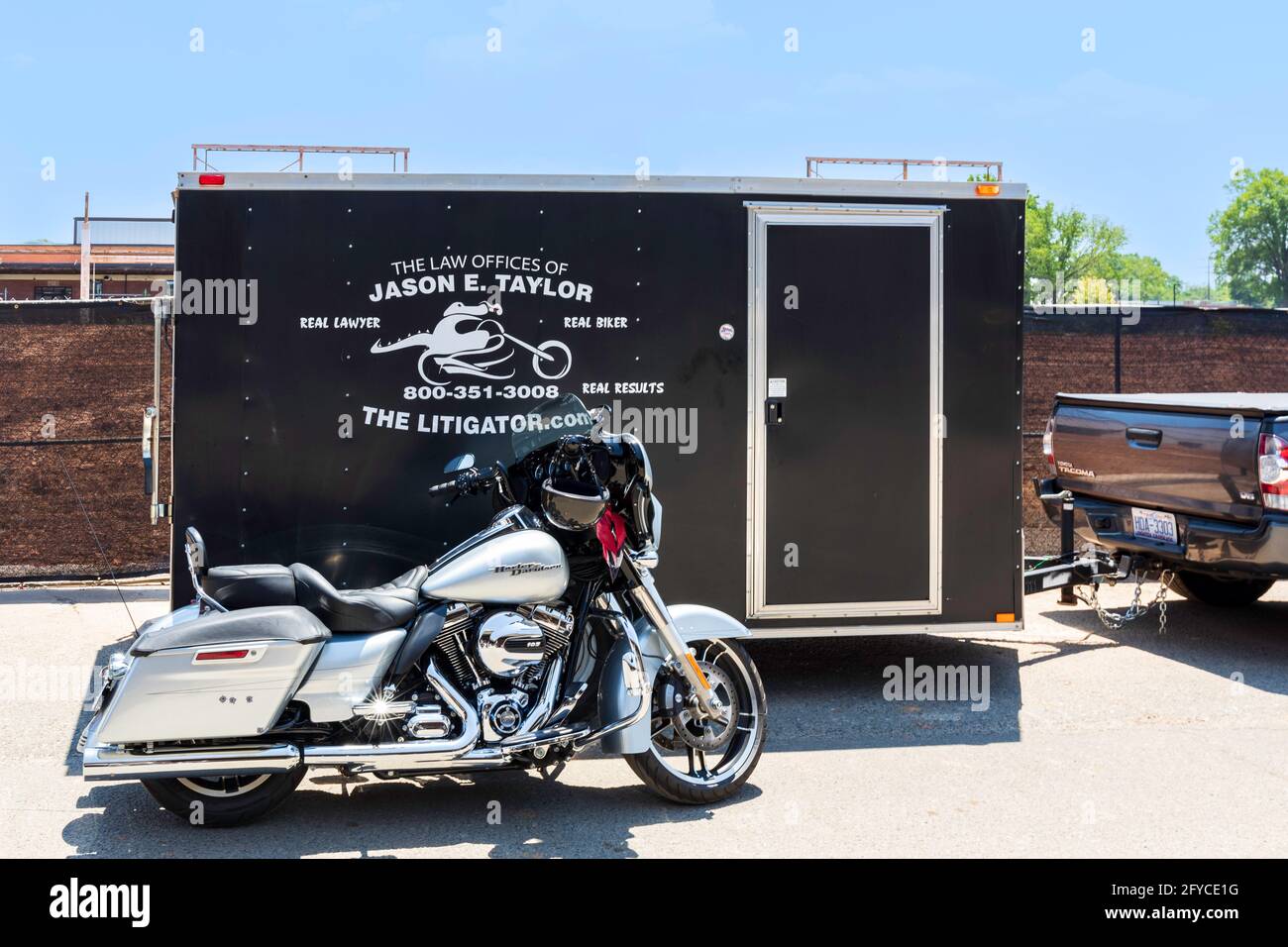 CHARLOTTE, NC, EE.UU.-23 DE MAYO de 2021: Camp North End. Un Harley-Davidson Street Glide aparcado al lado de un remolque con publicidad para un abogado de accidentes. Foto de stock