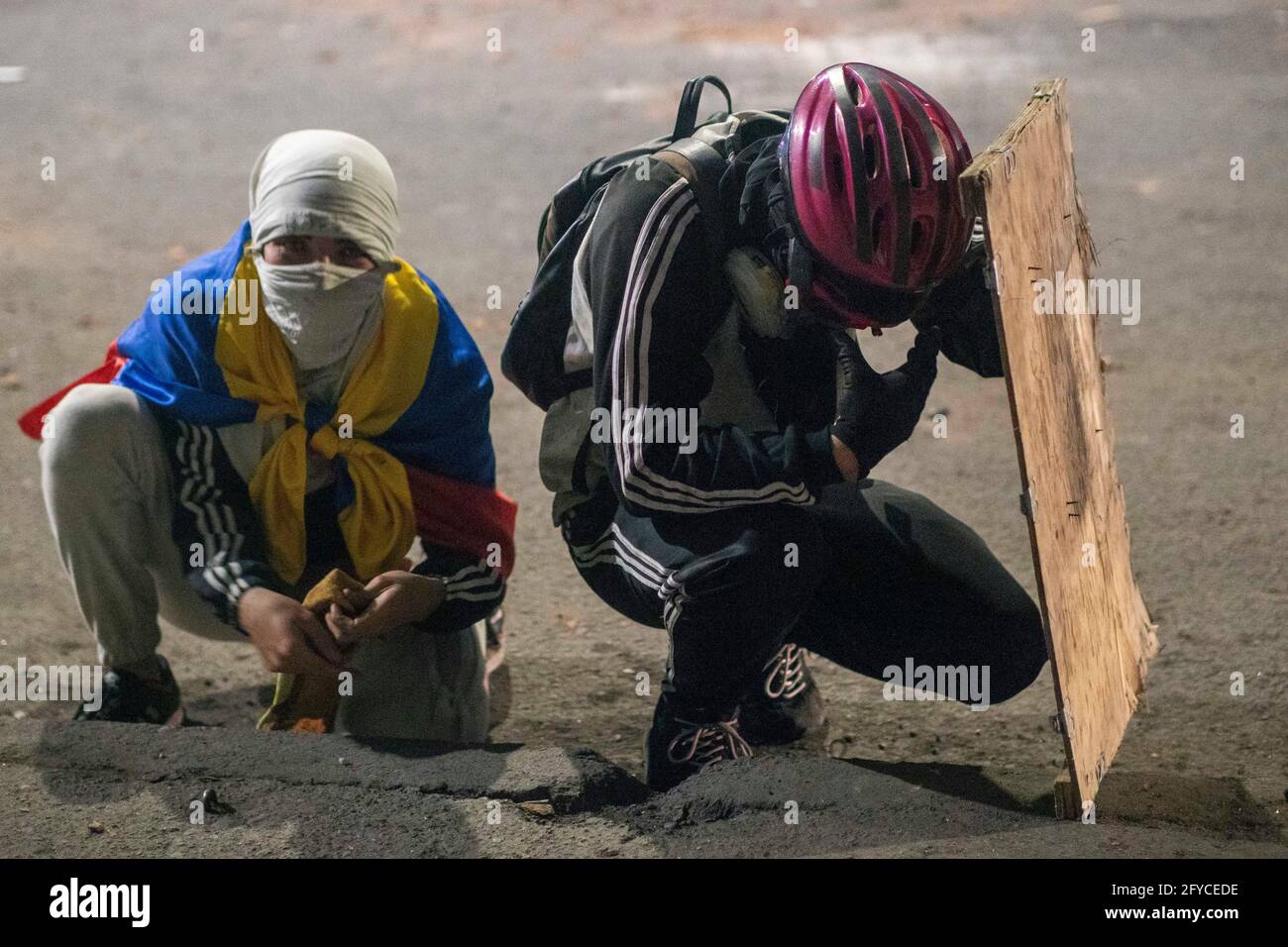 El extraño Planta Escarpado Bogotá, Colombia. 26th de mayo de 2021. Manifestantes usando cascos de  bicicleta y escudos improvisados para protegerse durante los  enfrentamientos con la policía antidisturbios en Bogotá. Docenas de  personas han muerto desde