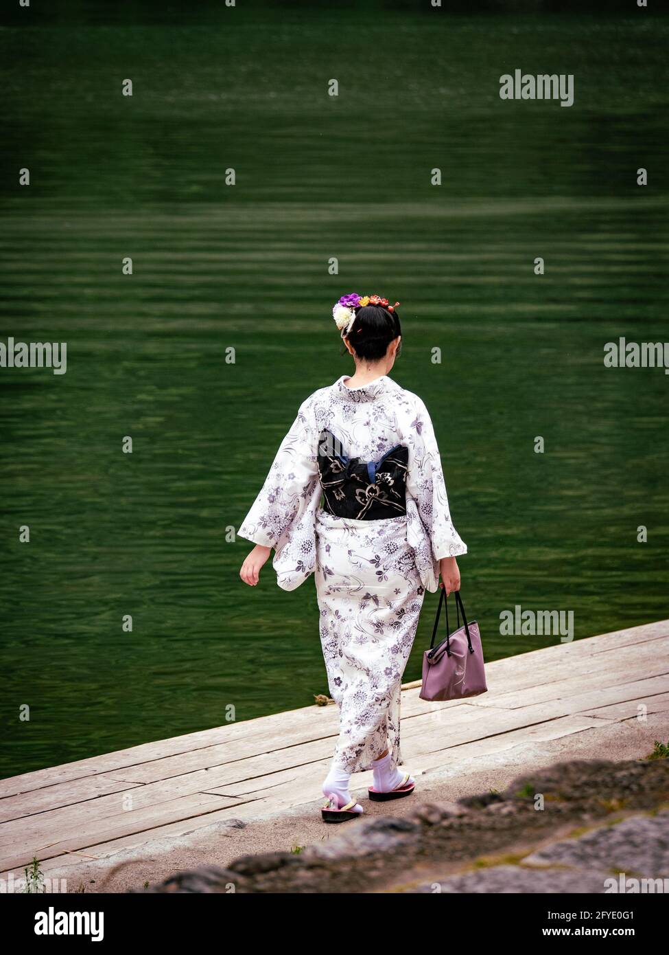 Espalda de mujer en kimono blanco con obi negro caminando a lo largo del  río Katsura, Arashiyama, Kyoto, Japón Fotografía de stock - Alamy