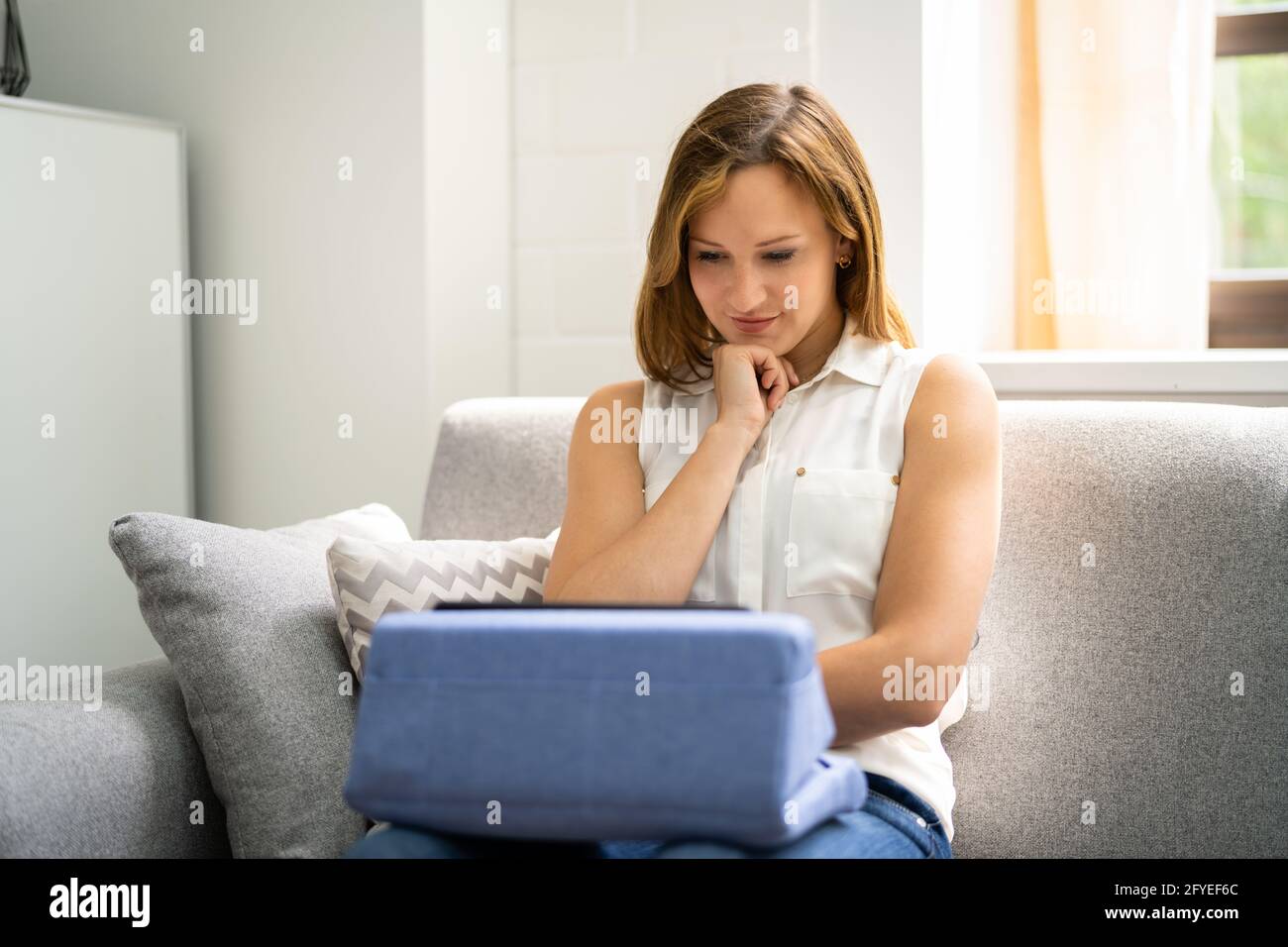 Mujer que usa la almohada de Tablet Lap para evitar el dolor de cuello  Fotografía de stock - Alamy